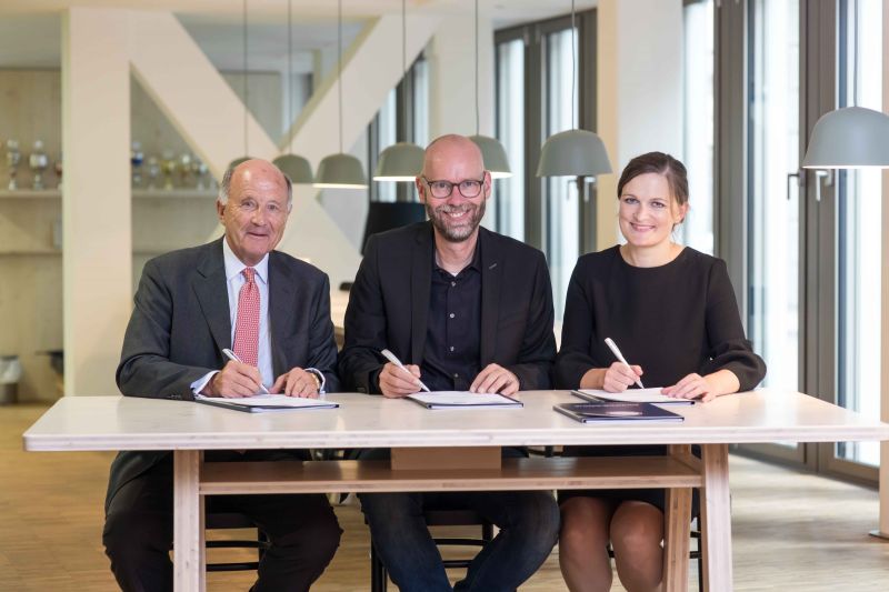 3 Personen sitzen am Tisch
